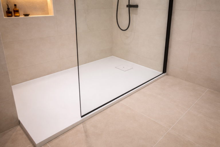 Plato de ducha instalado con mampara de cristal en baño reformado.